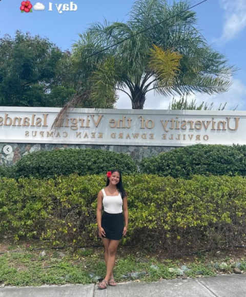 Student pictured in front of campus sign for UVI St. Thomas